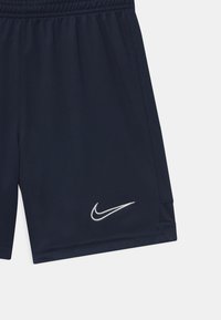 Pantalones cortos deportivos en navy con una cinturilla elástica, que presentan un logo de Nike bordado en blanco y acentos de malla transpirable en los laterales.