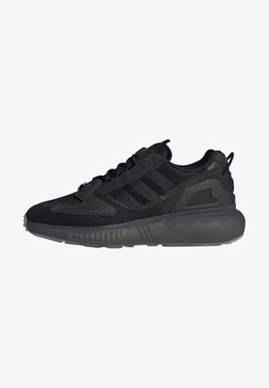 Zapatillas deportivas negras fabricadas con materiales de malla y sintéticos. Presentan tres rayas negras, acentos texturizados y una suela de goma.