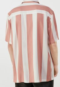 Camicia a maniche corte caratterizzata da ampie righe verticali in rosa cipria e bianco, realizzata in un tessuto morbido con colletto classico e schiena scoperta.