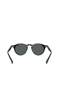 Occhiali da sole ovali neri con lenti scure, montatura in plastica lucida e aste sottili; design minimalista senza decorazioni o accenti.