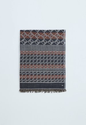 Tissu gris foncé et marron à motifs géométriques de diamants et de rayures, bordé de courtes franges sur un côté.