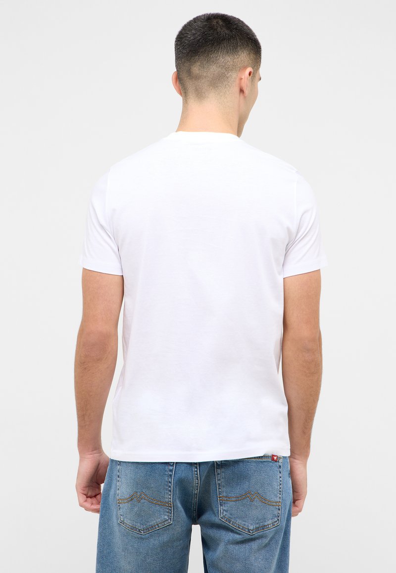 T-shirt blanc à manches courtes avec un col ras du cou, texture en coton lisse et coupe décontractée, associé à un jean en denim bleu clair.