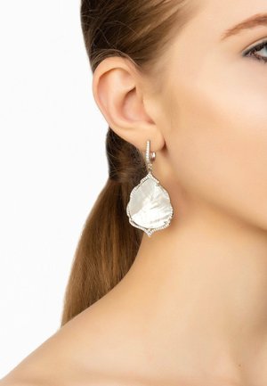 Silver-toned earrings featuring a large, pear-shaped mother-of-pearl drop embellished with small clear crystals along the edges.