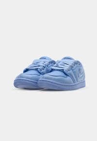 Šviesiai mėlyni Nike Air Jordan žemakulniai sportbačiai su sklandžiu zomšiniu paviršiumi, išskirtiniu raištelių sistemos dizainu ir formuoto logotipo detale šone.
