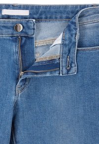Denim jeans featuring a light blue color, zipper fly, and a single button closure with visible stitching and pocket details.