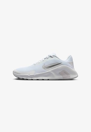 Białe buty sportowe z gładką syntetyczną cholewką, teksturowanymi paskami, srebrnym logo Nike oraz elastyczną gumową podeszwą z rowkami.