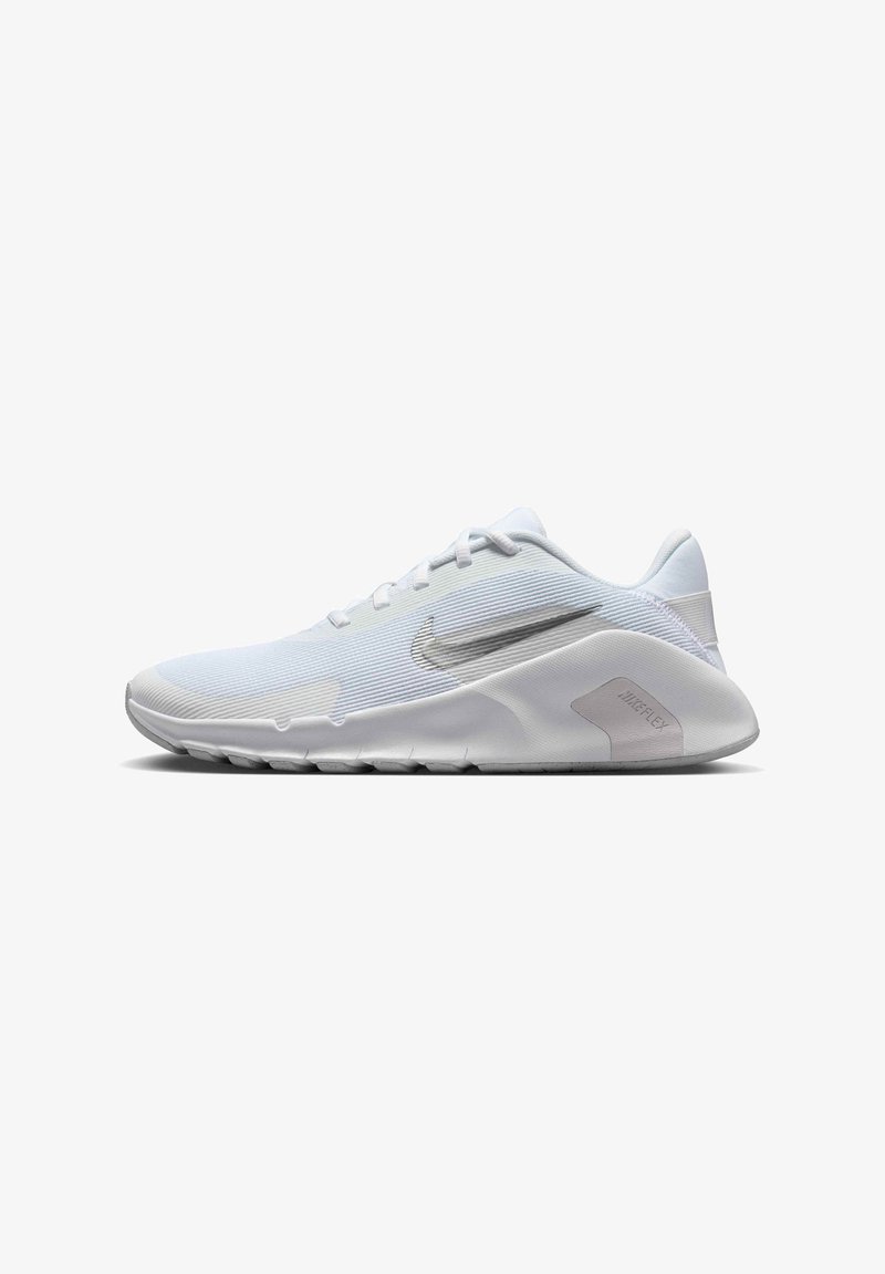 Valkoinen urheilujalkine, jossa on sileä synteettinen päällinen, tekstuuriset nauhat, hopeinen Nike-logo ja joustava kumipohja, jossa on urat.