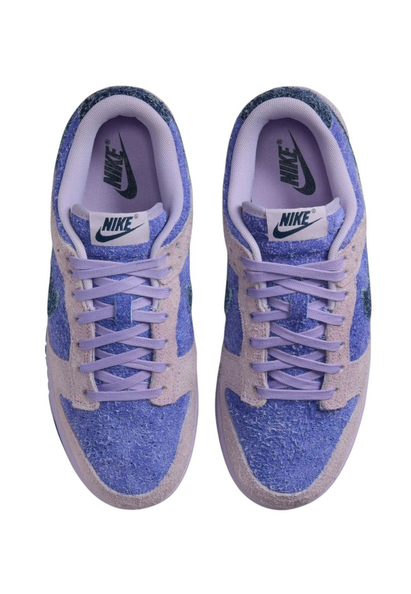 Baskets Nike avec une palette de couleurs lavande et bleue, en matériau en daim et en mesh, bout rond et lacets plats. Design classique et logo.