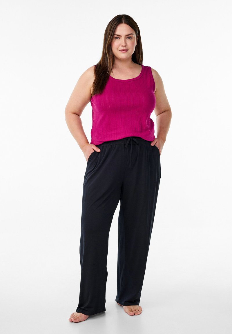 Haut sans manches fuchsia avec une texture côtelée associé à un pantalon noir ample avec une taille élastique à cordon.