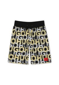 Maillots de bain noirs ornés d'un imprimé graphique audacieux avec de grandes lettres jaunes et blanches formant le mot "HUGO" sur un fond noir. Comprend un patch logo rouge.