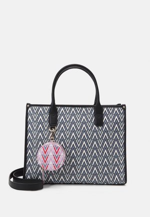 Sac fourre-tout à motif zigzag noir et blanc avec des poignées noires et un porte-clés rond détachable, arborant un design géométrique rose et rouge.