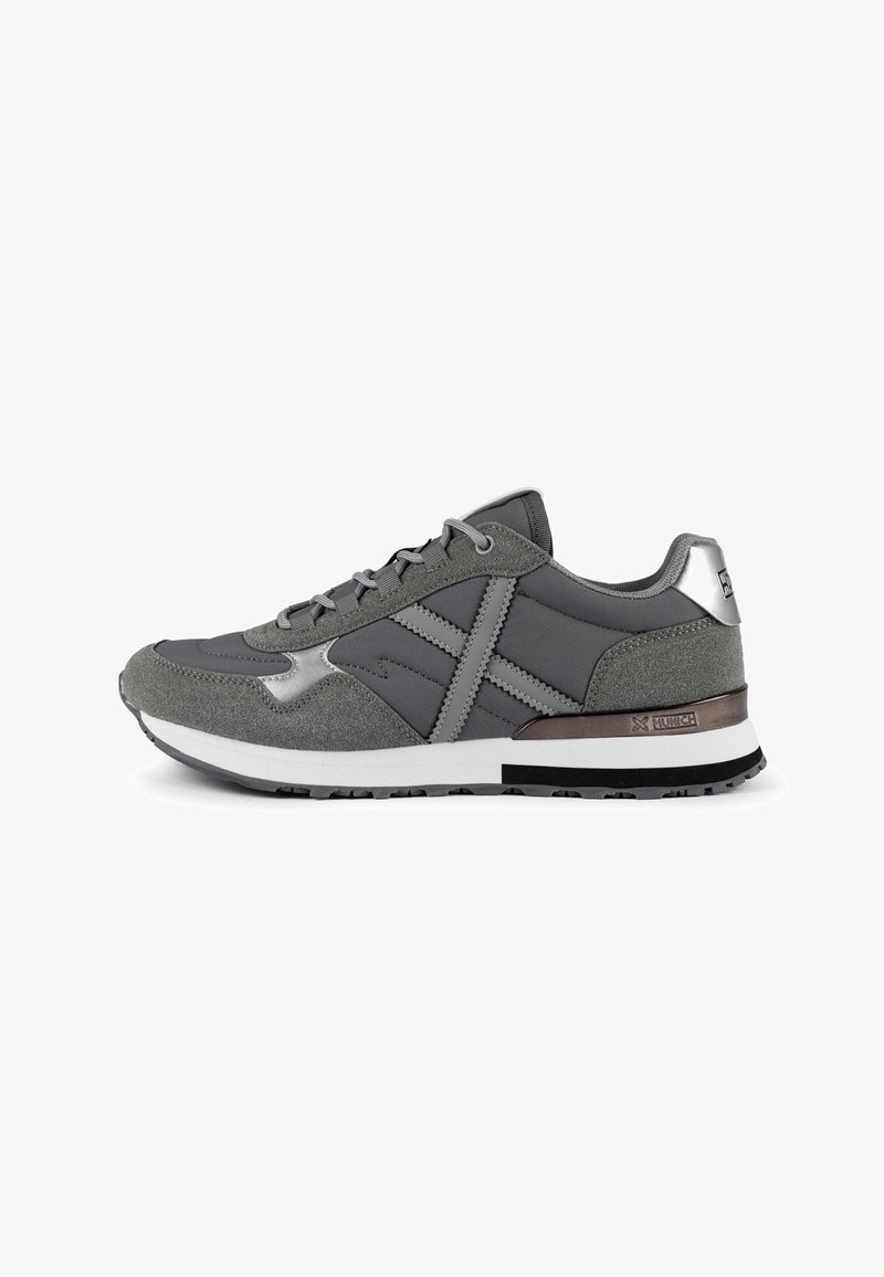 Gray athletic shoe featuring a mix of smooth and textured materials, with metallic accents and a cushioned white sole.