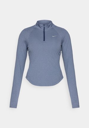 Langermet, zip-up athletic topp i en melert blå stoff med høy krage og en subtil Nike-logo på venstre bryst.