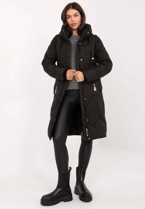 Black padded parka coat with a hood, zippered pockets, and a quilted texture; paired with black leggings and platform boots.