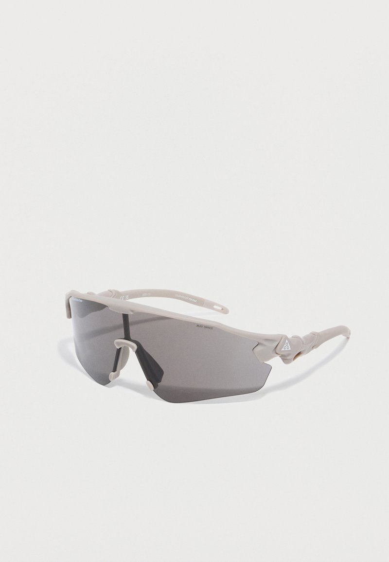 Αθλητικά γυαλιά ηλίου ανοιχτού γκρι με περιμετρικούς σκούρους φακούς και ευέλικτα πλαίσια σε λευκό φόντο.