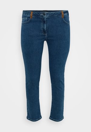 Jeans de ganga azuis com um corte slim, apresentando uma fecho com zip, detalhes em couro castanho na cintura e costura em contraste. Design clássico de cinco bolsos.