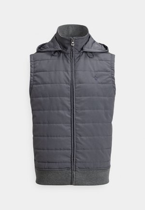 Pilka pūkinė liemenė su užtrauktuku priekyje, gobtuvu su raišteliais ir ribotu apvadu apačioje. Yra siuvinėtas raštas ir mažas logotipas ant krūtinės.