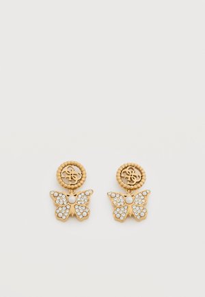 Boucles d'oreilles papillon en ton or avec centres en perle et accents en cristal, avec un emblème rond portant des initiales entrelacées en haut.