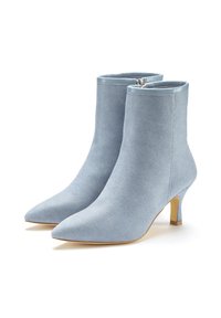 Botas de tobillo de mezclilla azul claro con punta afilada y un pequeño tacón apilado. Presentan un cierre de cremallera y una tela suave y texturizada.