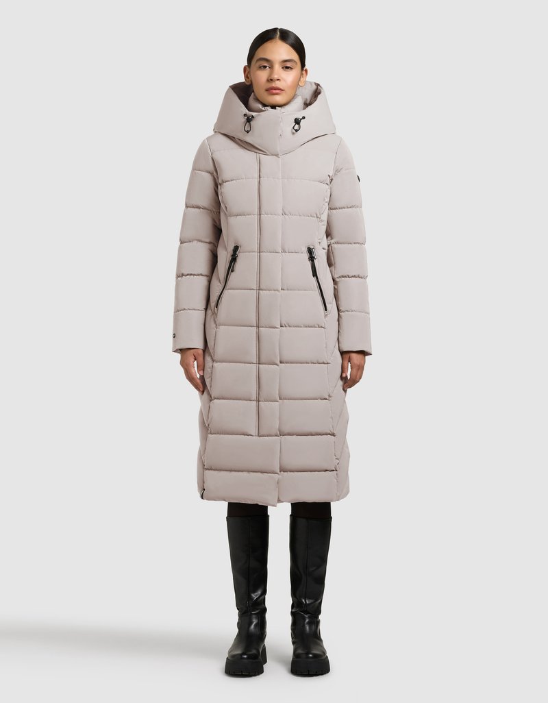 Svetlo siva puhasta jakna do kolen s prilagojenim kapucem, navpičnim vzorcem prešitega blaga, dvema stranskima žepoma z zadrgo in črnimi kovinskimi detajli.