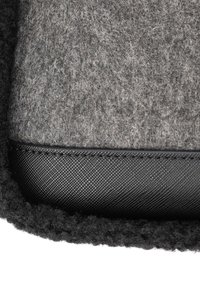 Grått filtmaterial med en strukturerad yta, kantad med svart syntetmaterial, med en elegant design och slät finish.