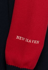 Maglione lavorato a maglia in rosso e blu navy. Presenta polsini e scollo a coste. "NEW HAVEN" ricamato in bianco sulla parte rossa.