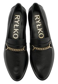 Mocassins en cuir noir avec une finition texturée, présentant un accent en chaîne dorée et deux détails en métal circulaires. Doublure intérieure douce.