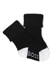 Calcetines de rayas negras con un puño doblado, que presentan la punta blanca y la palabra "BOSS" impresa en gris cerca de la zona de los dedos.