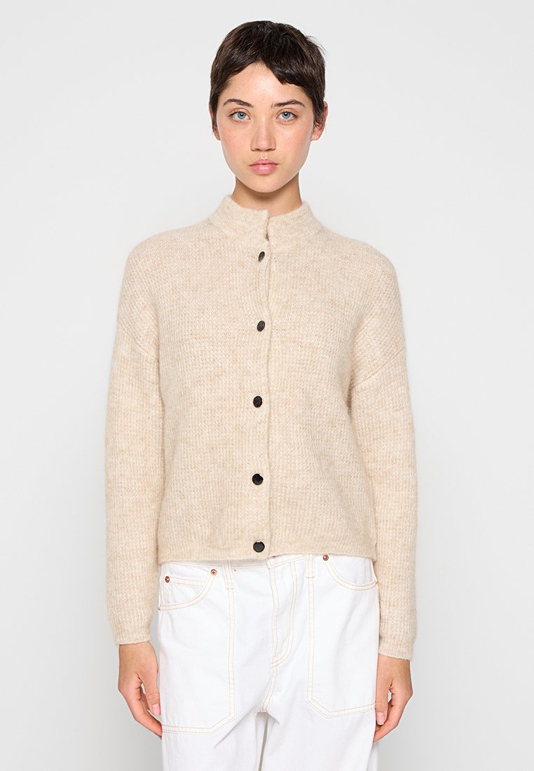 Beige gestrickte Strickjacke mit hohem Kragen und Vorderknöpfen, ausgestattet mit langen Ärmeln und einem lockeren Sitz. Weicher Stoff mit einem dezenten Muster.