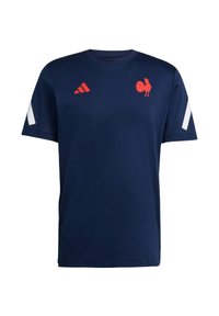 Marinblå t-shirt med kort ärm som har en röd tupplogotyp och röda Adidas-sträcker på vita detaljer vid axlarna. Mjuk tygkänsla.