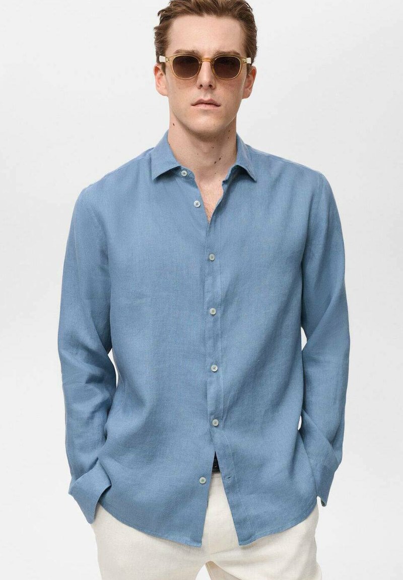 Light blue linen shirt with a button-down collar and long sleeves. Features a relaxed fit and buttons down the front.
