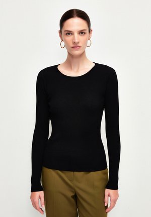 Zwarte geribbelde longsleeve top met een ronde halslijn. Strak ontwerp, zachte textuur en een gladde afwerking. Draagt met olijfgroene broek.