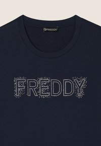 Camiseta de manga corta azul marino con cuello redondo y texto "FREDDY" adornado con strass transparentes. Material de algodón suave.