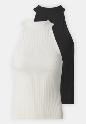 Geribde haltertops in zwart en wit. Heeft hoge halslijnen en een strakke pasvorm. Soepele textuur met contrasterende kleuren en minimale accenten.