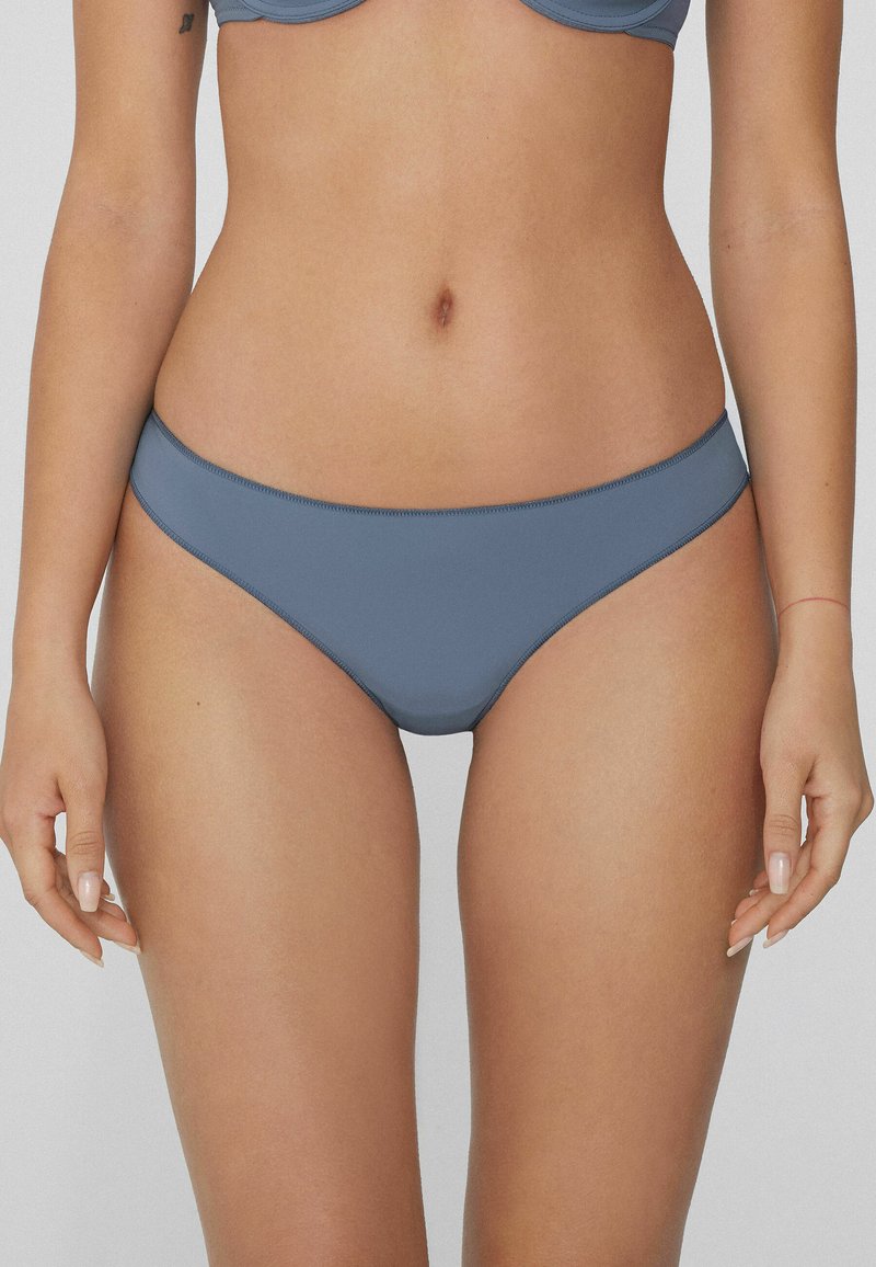 Graues Bikini-Unterteil aus glattem Stoff. Es hat einen niedrigen Schnitt und minimalen Schnitt mit genähten Kanten, geeignet für Bademode.