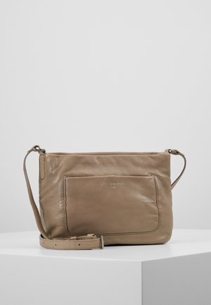 Sac bandoulière en cuir taupe doux avec poche avant, sangle réglable et embossage discret de la marque sur la poche.