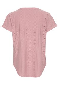 Haut rose clair à manches courtes présentant un motif en œillets texturé avec des formes de diamant et des découpes circulaires, légèrement arrondi à l'arrière.
