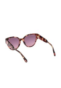 Occhiali da sole a forma di occhio di gatto in tartaruga con lenti viola sfumate e bracci sottili e curvi su sfondo bianco.