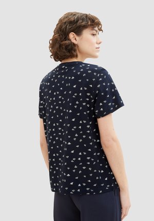 Navy short-sleeved t-shirt with a textured pattern of small, silver geometric shapes. Relaxed fit with a crew neck and a straight hem.