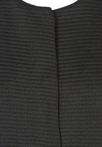 Czarny teksturowany materiał z poziomym prążkowanym wzorem, z przeszyciem z tyłu, tworzącym strukturalny wygląd.