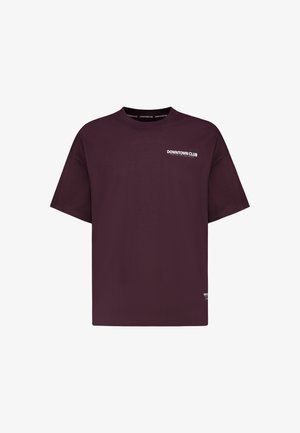 Dunkelviolettes, übergroßes T-Shirt mit kurzen Ärmeln und weißem "DOWNTOWN CLUB"-Text auf der linken Brust und im Krageninneren.