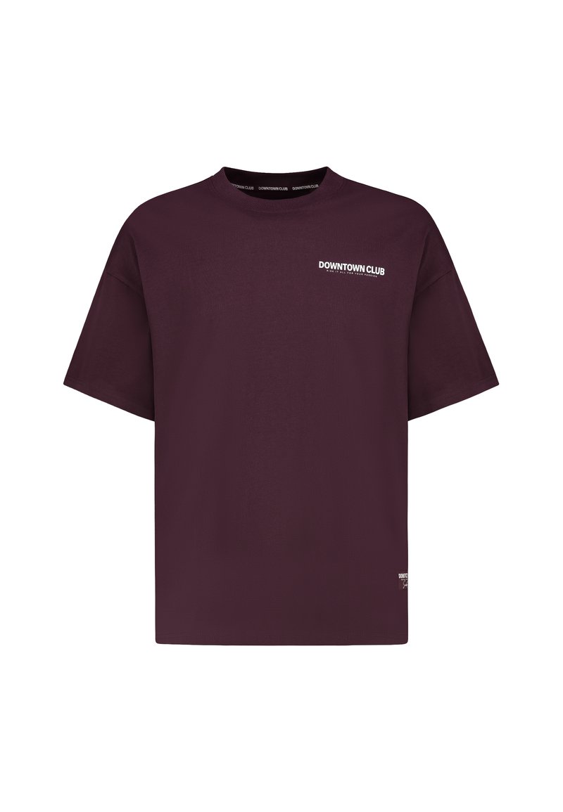 Dark purple oversized T-shirt with short sleeves and white "DOWNTOWN CLUB" text on the left chest and collar interior.