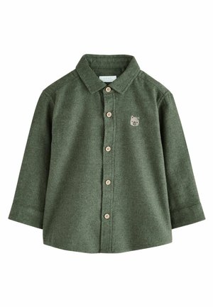 Zielona flanelowa koszula z długimi rękawami, zapięcie na guziki z przodu i beżowymi guzikami. Z przodu po lewej stronie znajduje się mały emblemat misia.