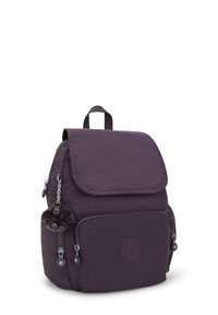 Lila tygryggsäck med lock, framficka och dragkedjedetaljer. Funkar som en fluffig charm-detalj och logotyp på framsidan.