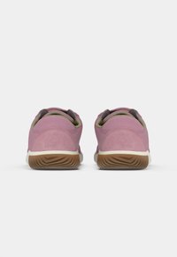 Lyserøde ruskinds sneakers med en rundet design, grå detaljer ved kraven, og en struktureret brun gummisål.