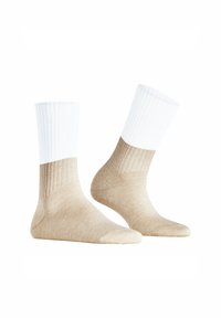 Beige und weiße Knöchelsocken mit gerippten Bündchen und einer glatten Textur, die einen Farbverlauf von Weiß zu Beige aufweisen.