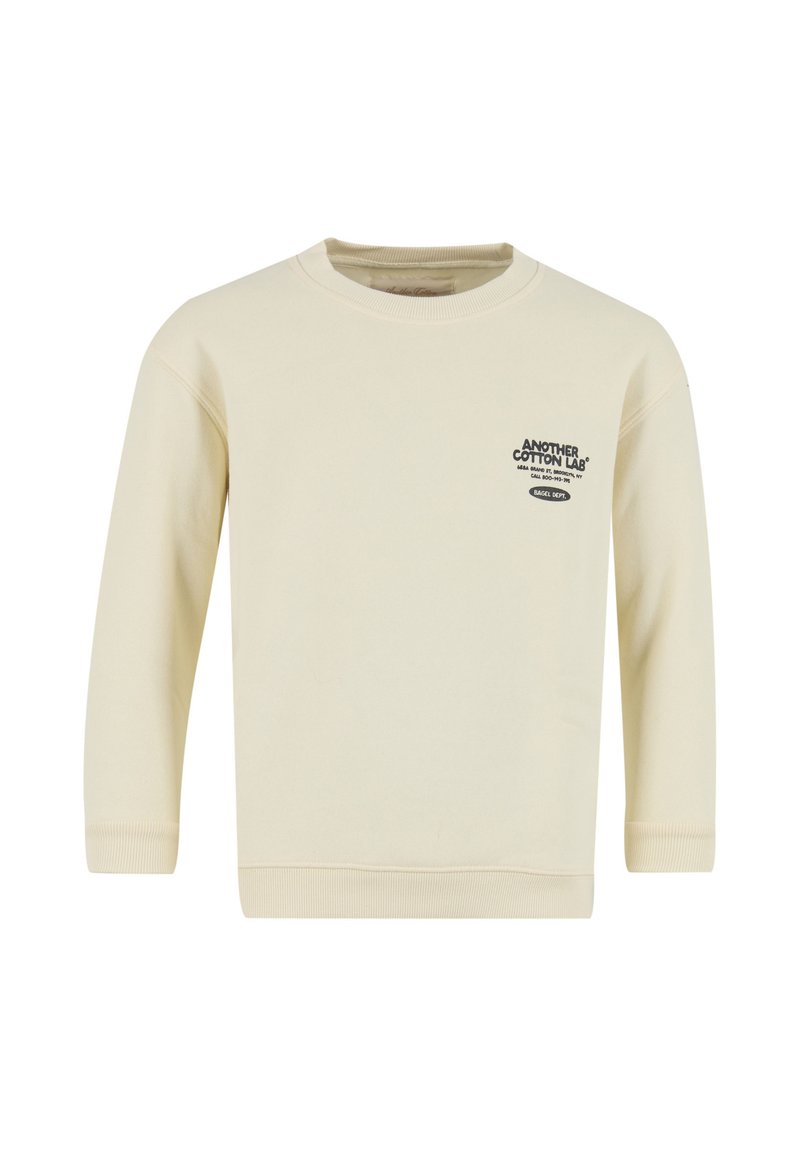 Světlý krémový mikina s dlouhými rukávy, žebrovanými manžetami a lemem. Na přední straně černý nápis s logem. Vyrobeno z měkkého bavlněného materiálu.