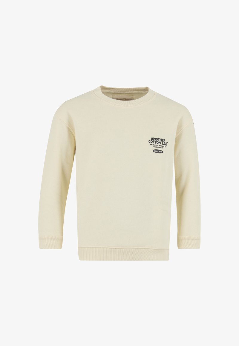 Světlý krémový mikina s dlouhými rukávy, žebrovanými manžetami a lemem. Na přední straně černý nápis s logem. Vyrobeno z měkkého bavlněného materiálu.