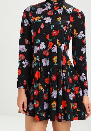 Robe noire à manches longues avec un col haut, ornée d'un motif floral en rouge, orange et violet. Conception de jupe évasée, tissu doux.