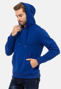 Blauer Baumwollhoodie mit einer Fronttasche, Kordelzügen und gerippten Bündchen. Hat eine lässige Passform und eine weiche Textur.